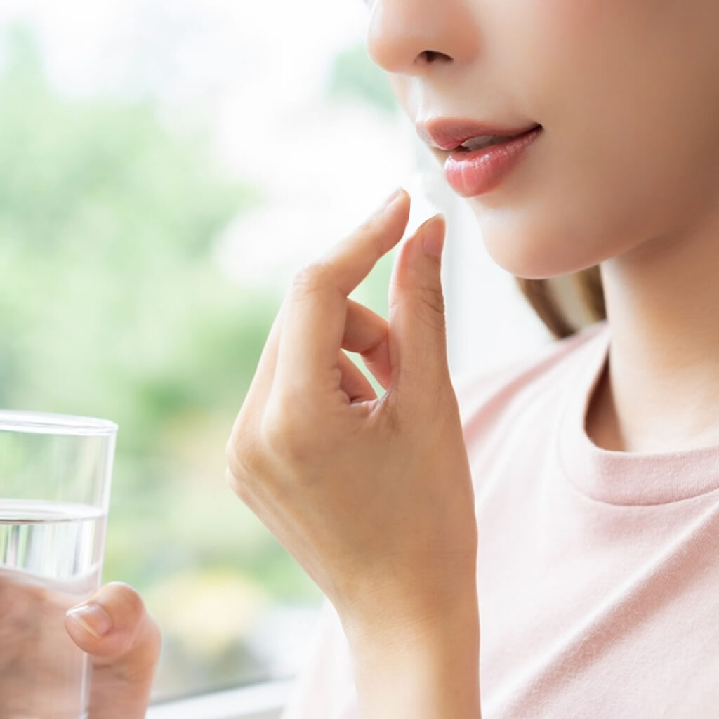 内服薬を飲んでいる女性