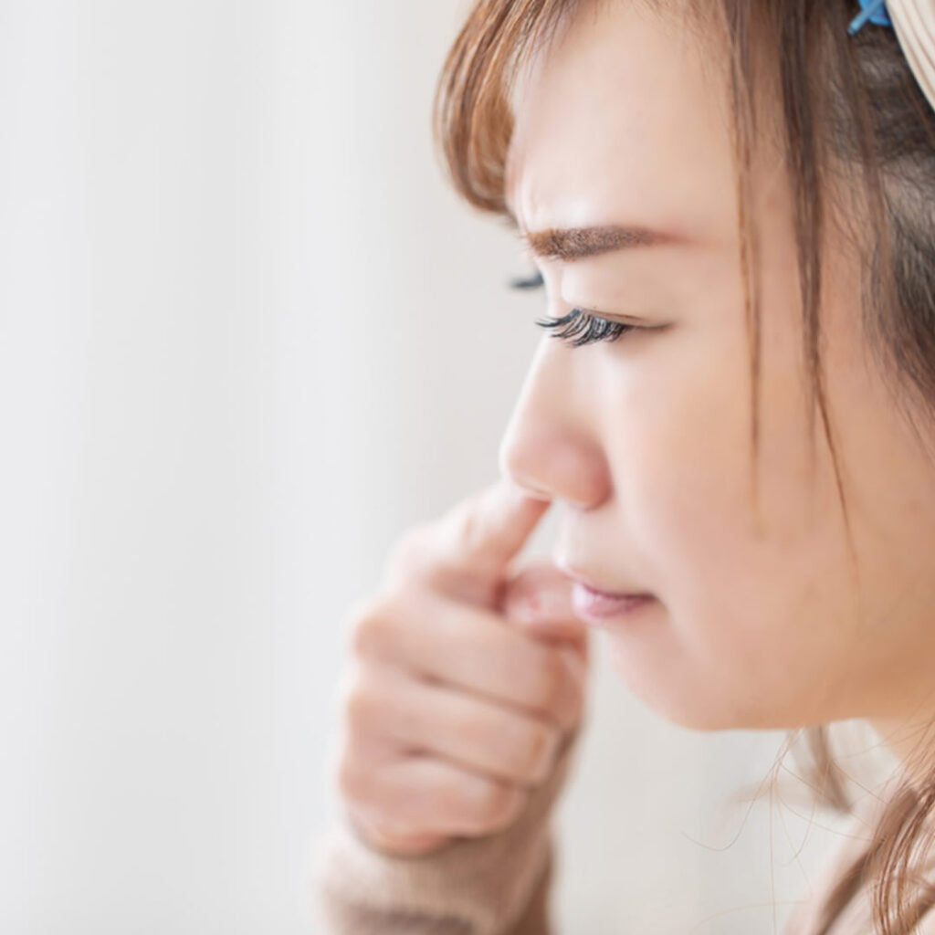鼻に指を入れている女性